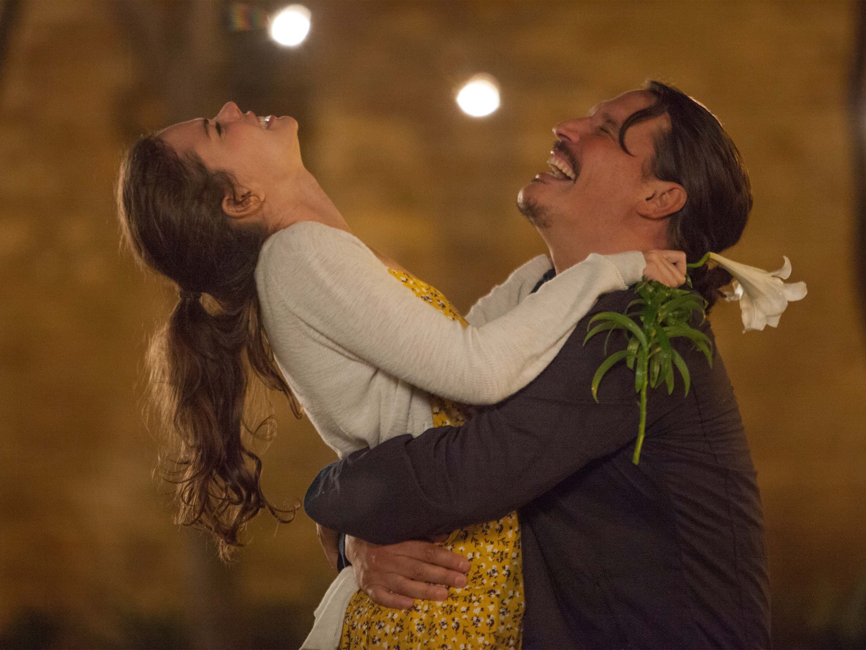 Ein Paar steht im Regen und umarmt sich.